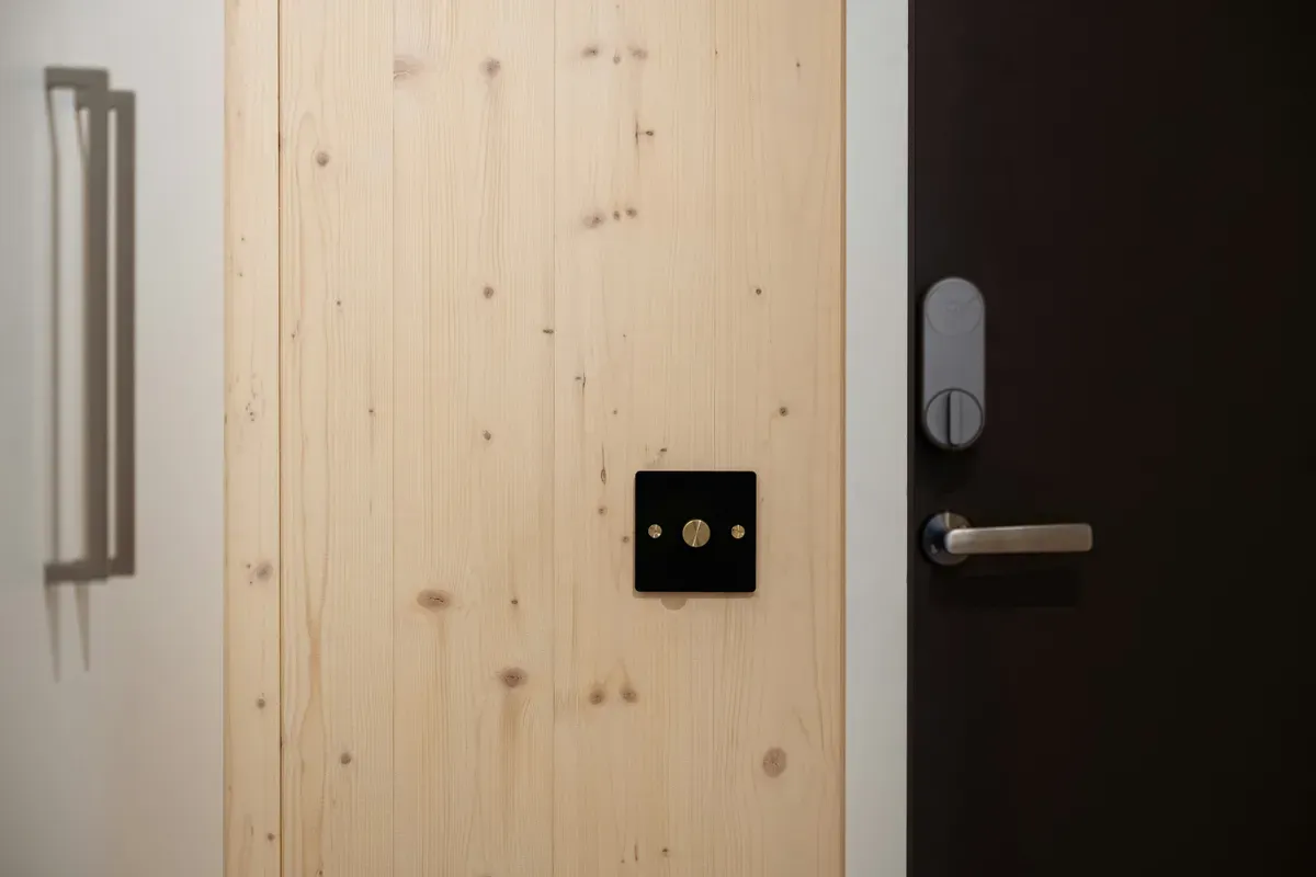 A black lever handle and lock fitted to a plain white door