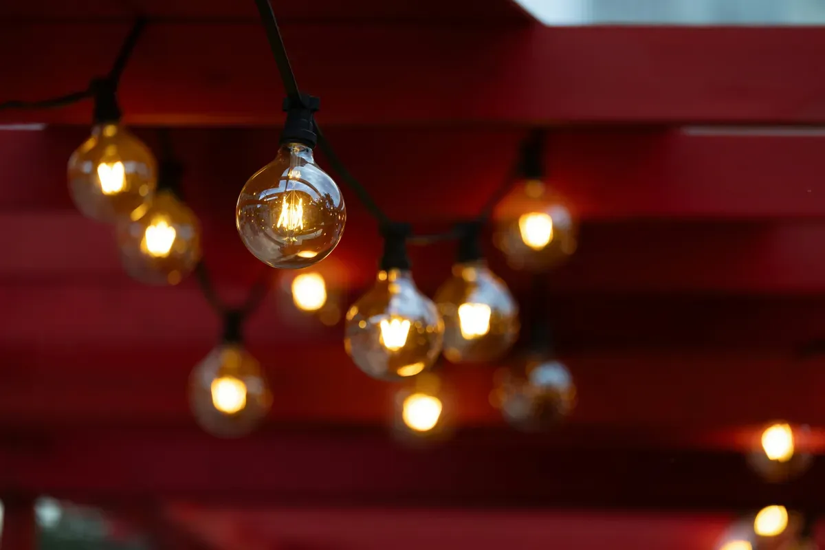 String lights glowing against a deep red wall