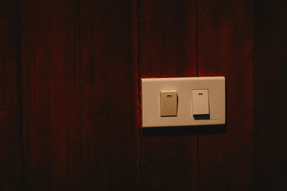 A white switch fitted to a wooden wall, the shape most Kasa gear replaces