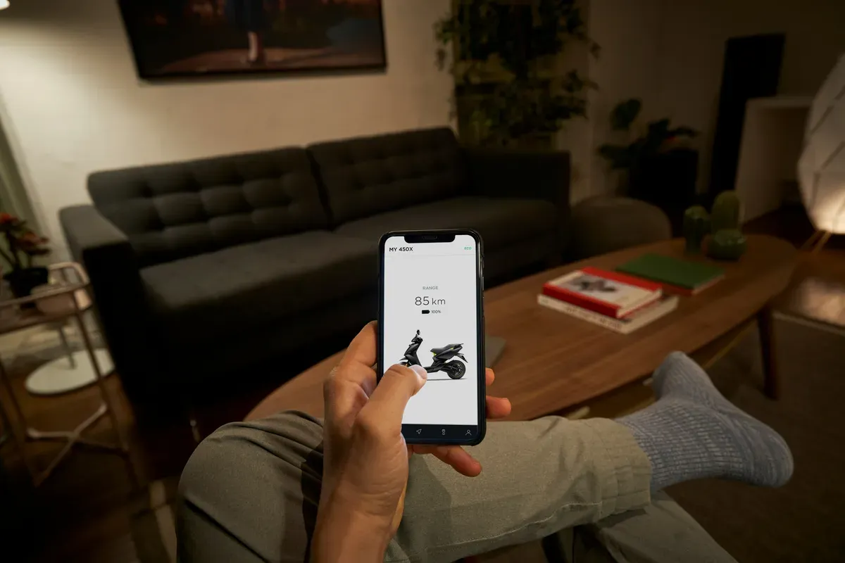 A hand holding a phone with a control app open on screen