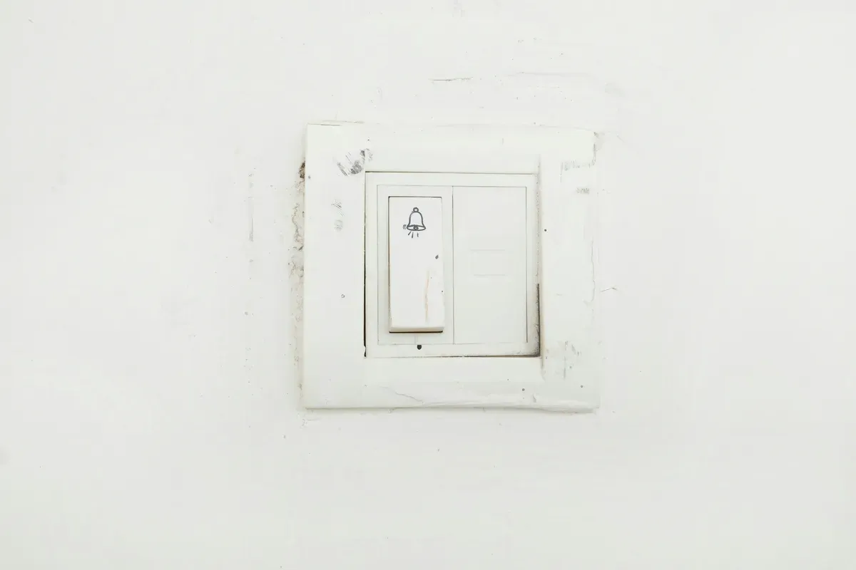 A white switch mounted on a white painted wall