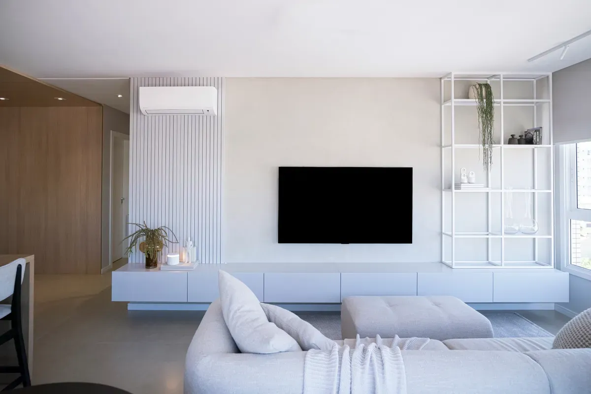 A large television on the wall of a bright living room