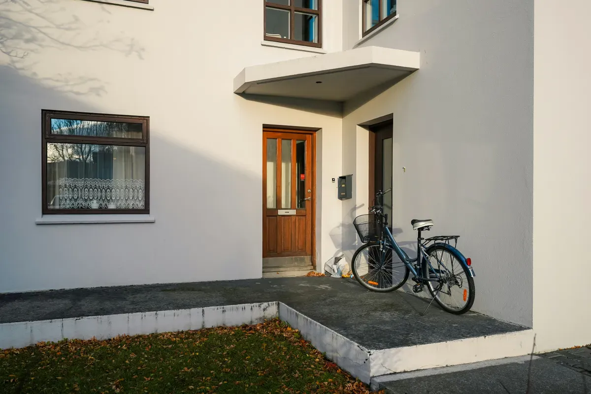 A bicycle parked outside a house entrance the doorbell watches