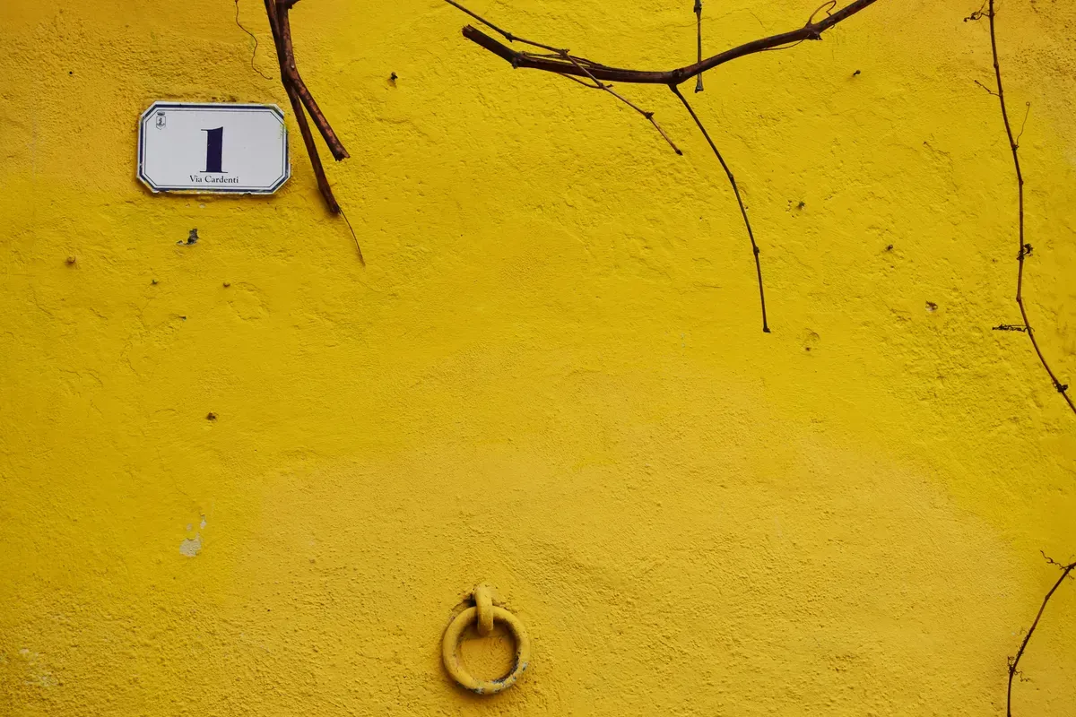 A yellow wall carrying a single painted number one