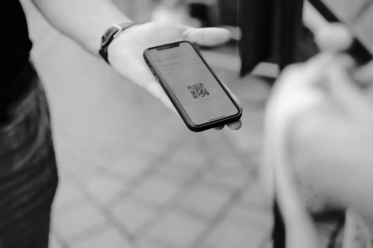 A person holding a smartphone, the device Aliro turns into the house key