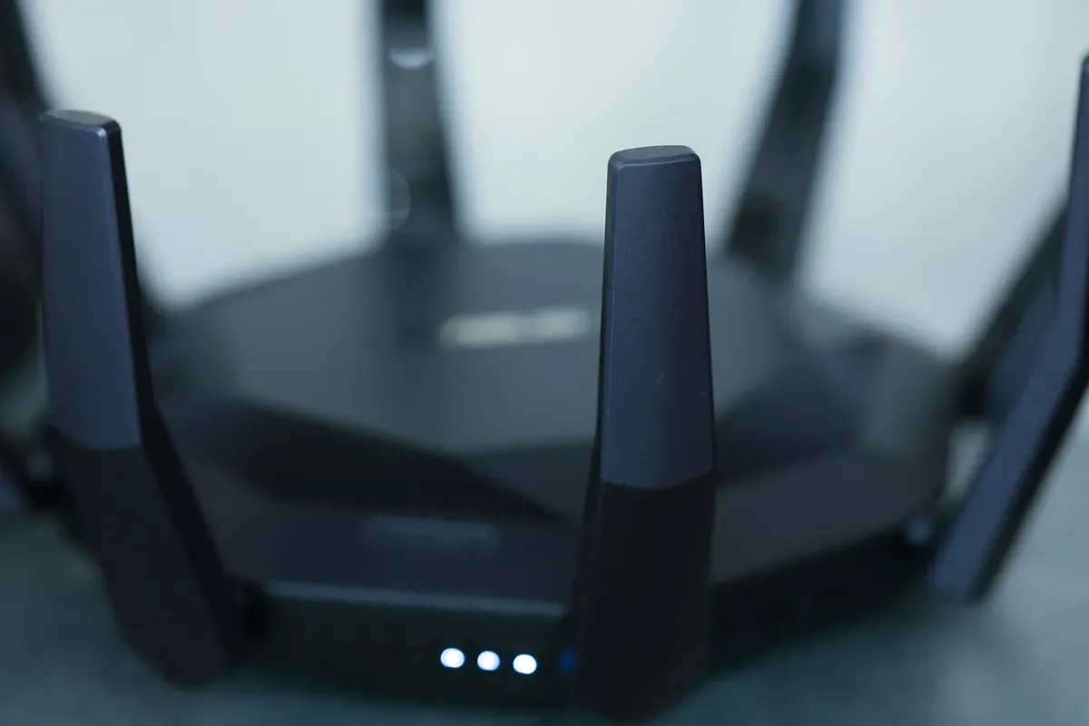 Wi-Fi router with several antennas and glowing indicator lights on a desk