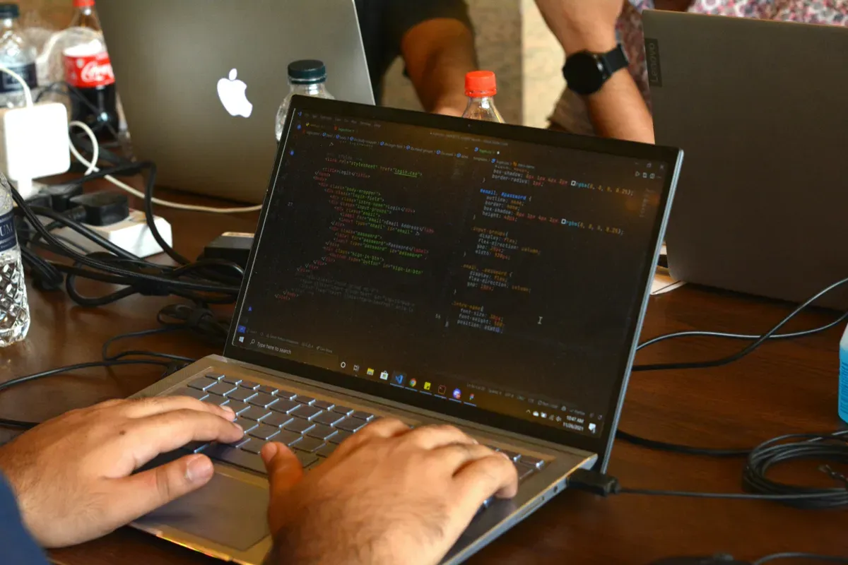 A person editing at a laptop on a wooden table