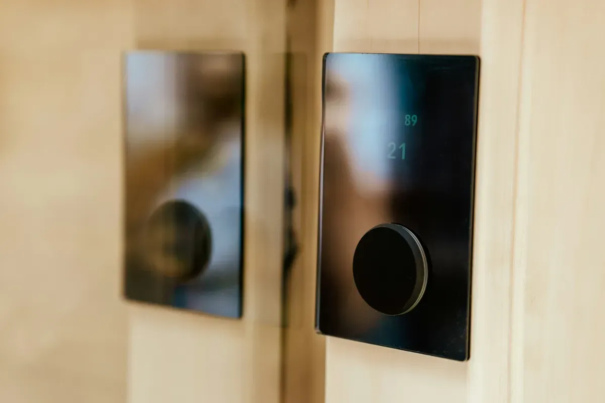A slim glass control panel mounted flat on a wall