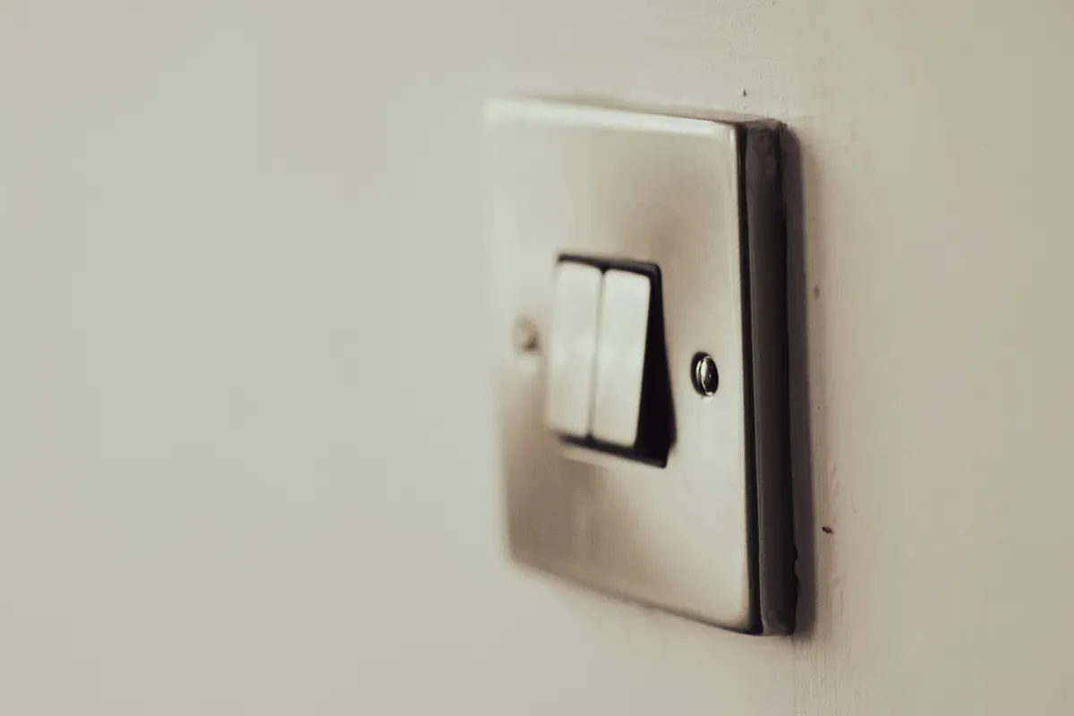 A twin rocker switch on a pale wall, still working when the bulb is dumb