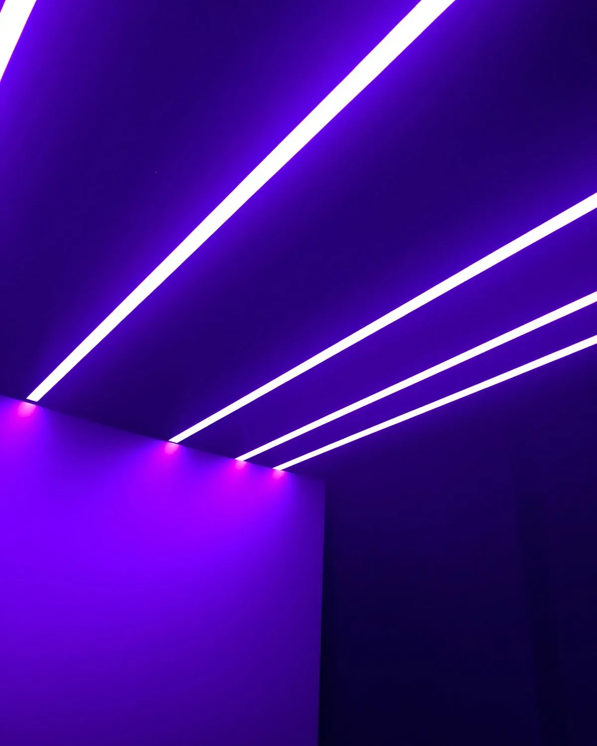 Room bathed in purple RGB smart lighting against a bright white wall