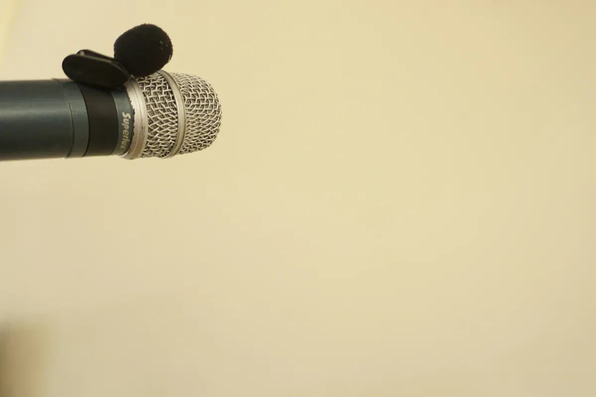 A microphone close up against a bare white wall