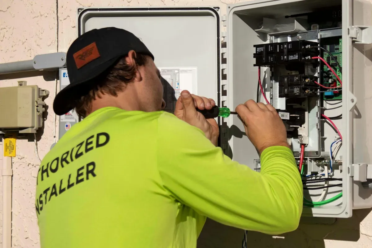 A screwdriver at work inside an open electrical panel