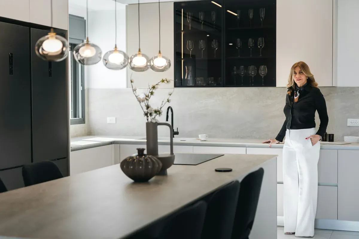 A person standing at a kitchen island in a room that stays tidy on a schedule