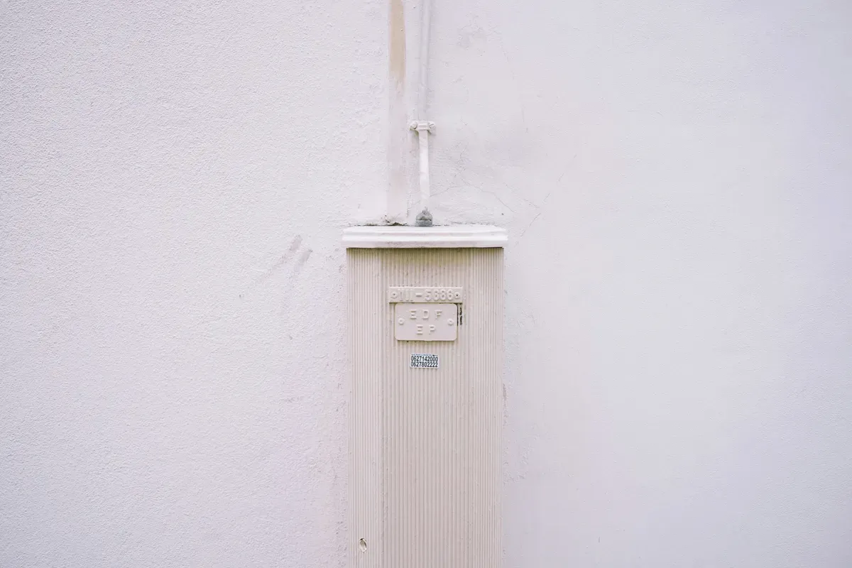 A white switch plate mounted alone on a column