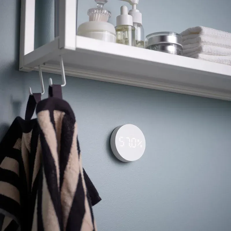 IKEA TIMMERFLOTTE mounted on a bathroom wall showing 57 percent humidity on its dot display
