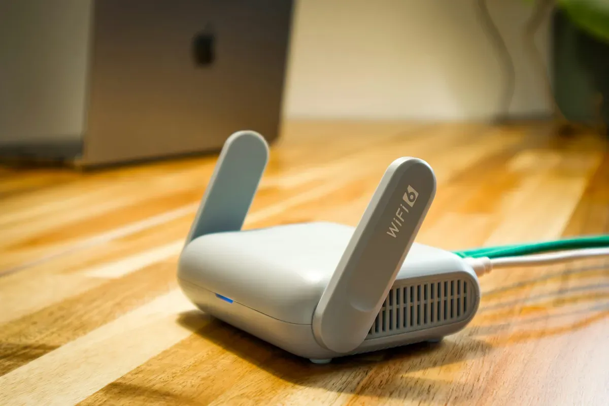 A wireless router with dual antennas standing on a desk