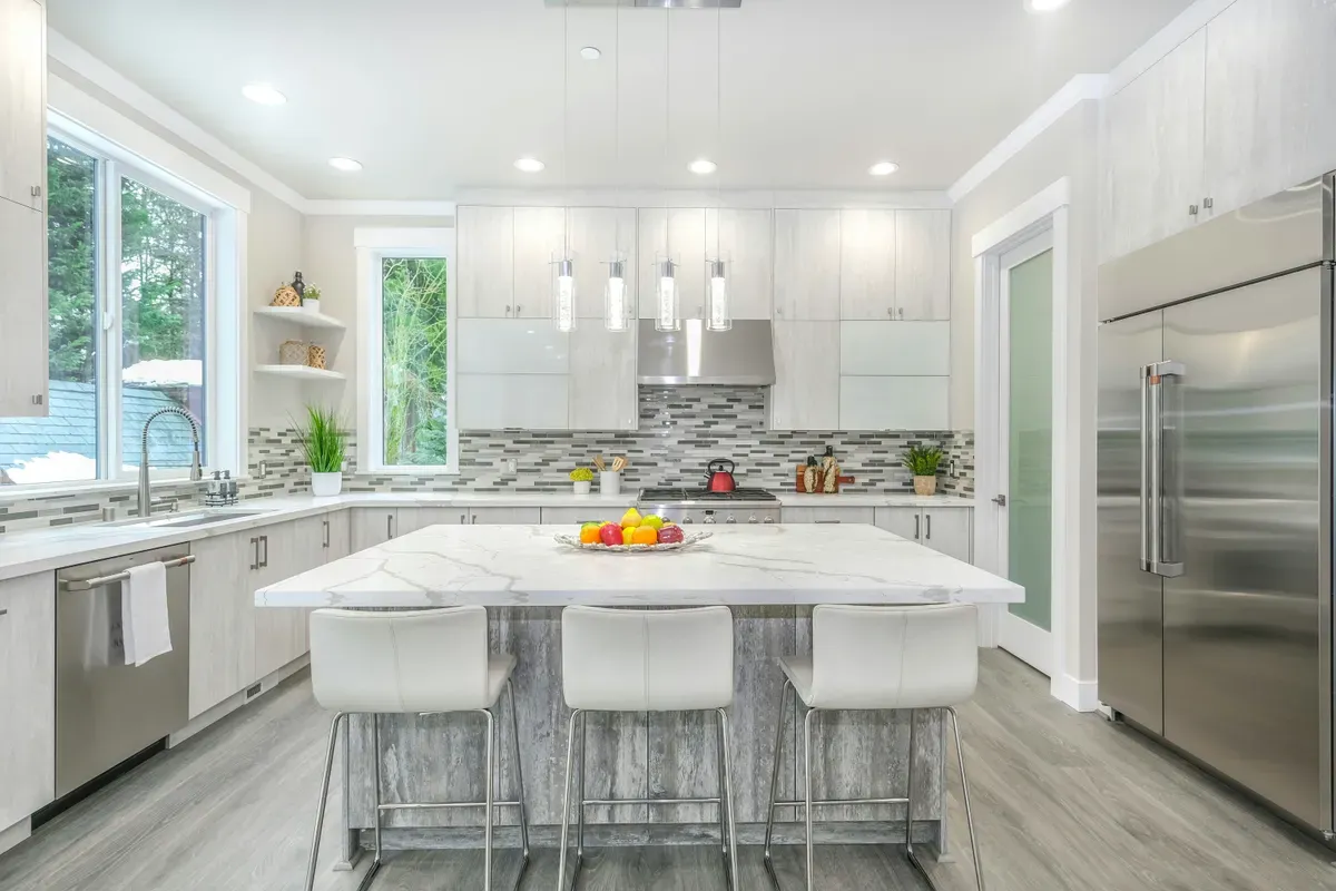 A bright kitchen with a white counter and wooden table